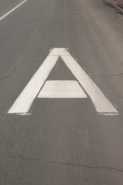 Het witte bord op de busbaan weg in de vorm van een grote hoofdletter een Rechtenvrije Stockfoto's