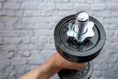 Adam ağırlık ile fiziksel antrenman yapıyor.