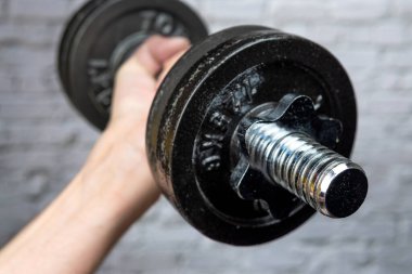 Adam ağırlık ile fiziksel antrenman yapıyor.