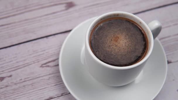 Remolino Espuma Una Taza Blanca Con Café Sobre Fondo Madera — Vídeos de Stock