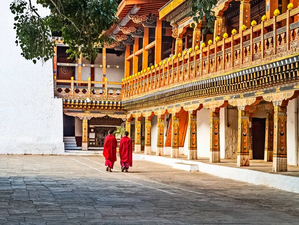 Dwóch Buddyjskich Mnichów Tradycyjnej Czerwonej Sukni Spacerujących Dziedzińcu Klasztoru Punakha — Zdjęcie stockowe