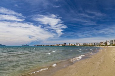 Arnavutluk 'un Vlora tatil beldesinin plajı. Yaz güneşli bir gün. Şehir ve Adriyatik Denizi manzarası