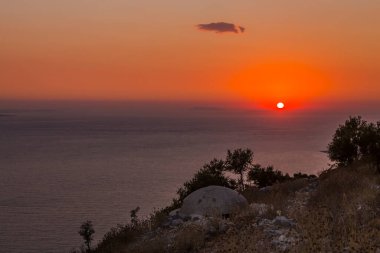 Enver Hoca 'nın komünist hükümeti tarafından Arnavutluk' un güneyinde deniz batımının arka planında inşa edilen sayısız askeri beton sığınak veya makineli tüfek yuvalarından birine yakın plan.