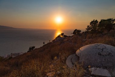 Enver Hoca 'nın komünist hükümeti tarafından Arnavutluk' un güneyinde deniz batımının arka planında inşa edilen sayısız askeri beton sığınak veya makineli tüfek yuvalarından birine yakın plan.