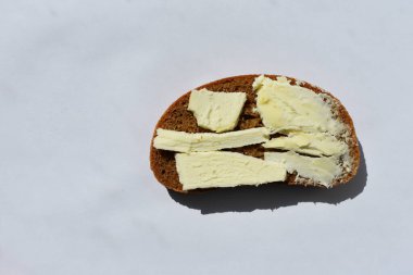 Bir parça siyah ekmek üzerinde tereyağı