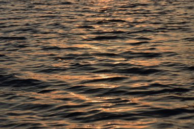 Gölde gün batımı. Altın su yüzeyine yakın çekim