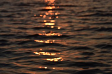 Gölde gün batımı. Altın su yüzeyine yakın çekim