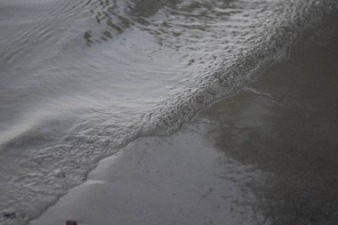 Kumsalda dalgalar, yakın çekim, sığ alan derinliği