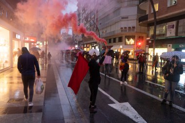 Uluslararası Kadınlar Günü 'nde 8M' de kadınların haklarını protesto etmek için kırmızı işaret fişeği yakan kız