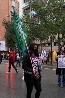 Kadın, kadın hakları için bir protesto posteri tutuyor. Yağmur yağarken ortaya çıkan bir tezahürat.