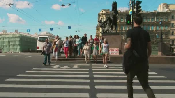 Bei sonnigem Wetter überqueren Menschenmassen bis zur Unkenntlichkeit belebte Straßenkreuzungen in der Stadt. St. Petersburg, Russland. Tourismus. 4K — Stockvideo