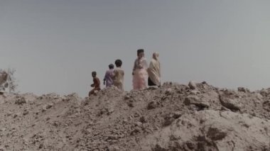 Pakistan 'da bir tuğla fabrikasının bölgesinde beş köle çocuğu yürüyor. İşçi köleliğindeki çocuklar. Ağır çekim. Karachi, Pakistan - Eylül 2021