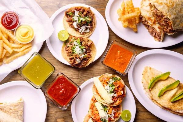 Meksika yemeği geçmişi. Meksika yemeği partisi. Tahta masada Meksika yemeği konsepti. Geleneksel Meksika yemekleri. Meksika tacoları
