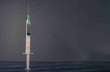 Siyah pencere gölgeli mavi ahşap masa üzerinde şırınga. 2021 yılında Covid-19 aşı konsepti. Coronavirus aşısı