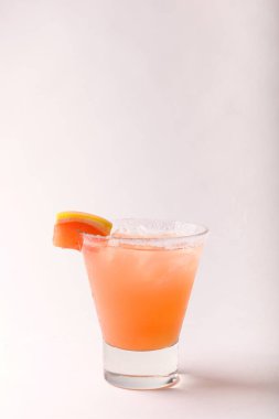 Beyaz arka planda votka ve limon dilimli meyve karışımı. Sıcak renkli kokteyller. Renkli kokteyl. Kokteyl konsepti.