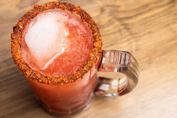 Michelada birası ve domates suyu. Tahta masada biralı Clamato. Meksika içki konsepti