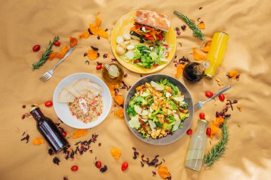 Yaz pikniği atmosferi, çimenlikte masa örtüsü, sağlıklı yiyecek ve meyve içecekleri. Düz yerde yemek vardı. Zeytinyağı, salata, sandviç, kinoa salatası, vegan burger..