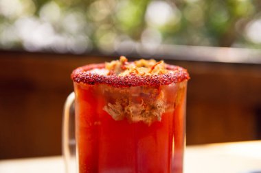 Michelada birası ve domates suyu. Tahta masada biralı Clamato. Meksika içkisi. Domates suyu, karides, midye ve limon ile Michelada birası, Meksika 'da Meksika içkisi. Meksika birası kavramı.