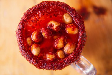 Michelada birası ve domates suyu. Tahta masada biralı Clamato. Meksika içkisi. Domates suyu, karides, midye ve limon ile Michelada birası, Meksika 'da Meksika içkisi. Meksika birası kavramı.