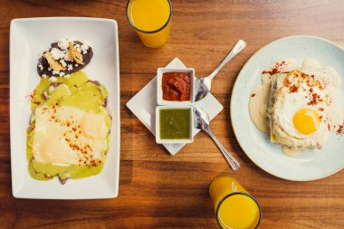 Tahta masada kahvaltıda portakal suyu ile birlikte iki yumurta tabağı. Sağlıklı gıda konsepti. Düz yerde, üst tarafta. Gurme yemek kavramı