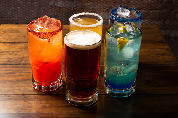 Красочные тонированные коктейли на деревянном фоне. Фрутальные алкогольные коктейли. Красочная концепция напитков на деревянном столе