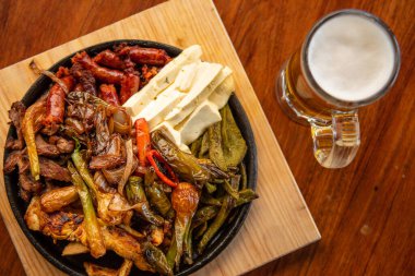 Hakiki Meksika barbeküsü, restoran masasında kızartılmış farklı kesikler. Chistorra, et ve ızgara peynir. Meksika bifteği konsepti.