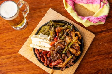 Hakiki Meksika barbeküsü, restoran masasında kızartılmış farklı kesikler. Chistorra, et ve ızgara peynir. Meksika bifteği konsepti.