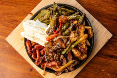 Hakiki Meksika barbeküsü, restoran masasında kızartılmış farklı kesikler. Chistorra, et ve ızgara peynir. Meksika bifteği konsepti.