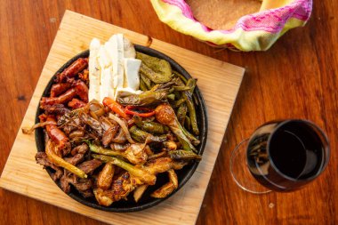 Hakiki Meksika barbeküsü, restoran masasında kızartılmış farklı kesikler. Chistorra, et ve ızgara peynir. Meksika bifteği konsepti.