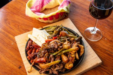 Hakiki Meksika barbeküsü, restoran masasında kızartılmış farklı kesikler. Chistorra, et ve ızgara peynir. Meksika bifteği konsepti.