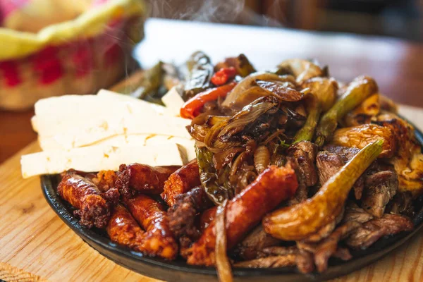 Hakiki Meksika barbeküsü, restoran masasında kızartılmış farklı kesikler. Chistorra, et ve ızgara peynir. Meksika bifteği konsepti.