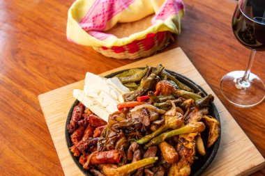 Hakiki Meksika barbeküsü, restoran masasında kızartılmış farklı kesikler. Chistorra, et ve ızgara peynir. Meksika bifteği konsepti.