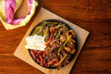 Hakiki Meksika barbeküsü, restoran masasında kızartılmış farklı kesikler. Chistorra, et ve ızgara peynir. Meksika bifteği konsepti.