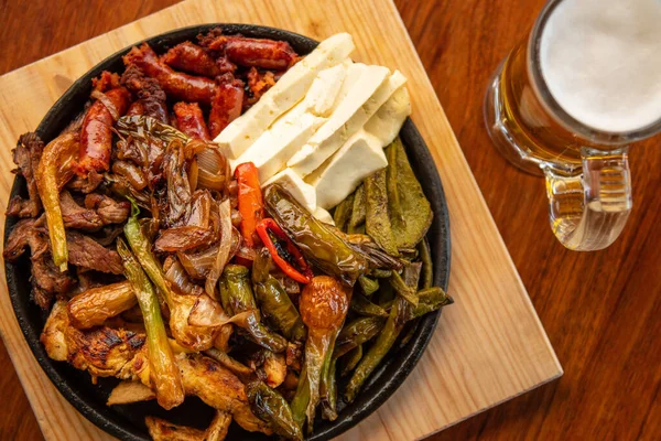 Hakiki Meksika barbeküsü, restoran masasında kızartılmış farklı kesikler. Chistorra, et ve ızgara peynir. Meksika bifteği konsepti.