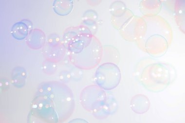 Soyut, güzel renkli parlak sabun köpükleri yüzer arka planda.