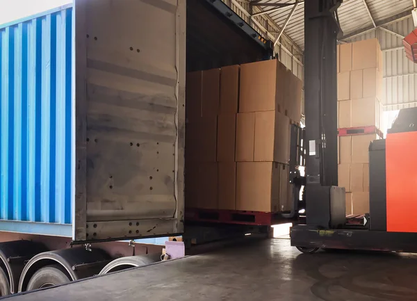 Kargo kamyona yükleniyor. Lojistik ve ulaşım depoları, yük paletini kamyona yükleyen forklift sürücüsü .