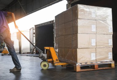 Depo işçisi içerideki kargo konteynırından paket kutusunu boşaltıyor. Rıhtım deposuna yüklü kamyon. Teslimat servisi. Depo Lojistiği sevkiyatı. Nakliye Aracı Taşımacılığı.