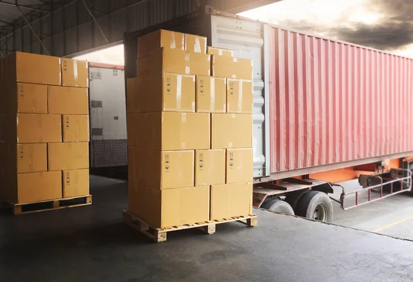 Stack of Package Boxes Load with Cargo Container. Trailer Truck Parked Loading at Dock Warehouse. Delivery Service. Shipping Warehouse Logistics. Cargo Freight Truck Transport.