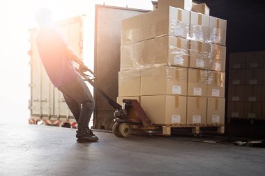 Depo işçisi içerideki kargo konteynırından paket kutusunu boşaltıyor. Rıhtım deposuna yüklü kamyon. Teslimat servisi. Depo Lojistiği sevkiyatı. Nakliye Aracı Taşımacılığı.