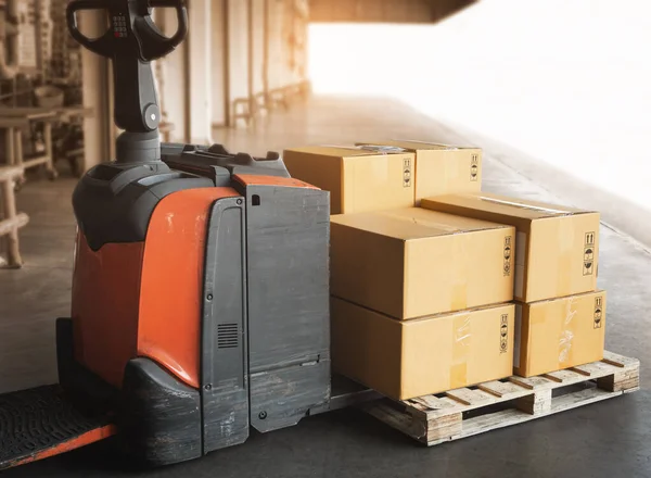 Electric Forklift Pallet Jack with Package Boxes on Pallet at The Warehouse. Shipping Warehouse Logistics.