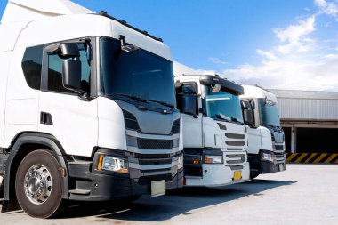 Depo 'daki otoparkta yarı kamyonlar. Traktör kamyonu. Kargo konteynırı. Rıhtım deposunda yük kamyonu var. Dağıtım Deposu. Büyük kamyon. Nakliye Aracı Taşımacılığı.