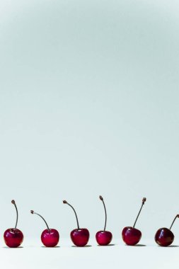 Resmin altında kırmızı kirazlı dikey beyaz yaz arkaplanı.