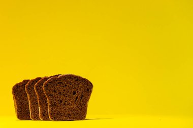 Dört dilim ekşi ekmek, parlak sarı arka planda yan yana durur..
