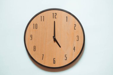 Siyah rakamlı tahta duvar saati ve saat beş yönünde siyah eller..