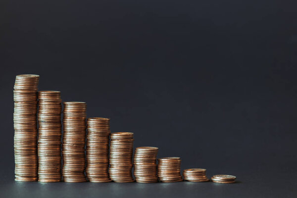 Falling graph in the form of gold coins on a black background.