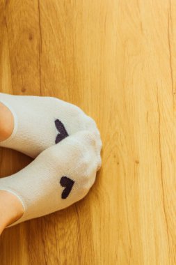 Kısa çoraplı bacaklar ahşap arka planda.