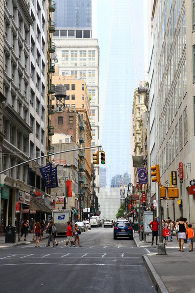An ordinary street in Manhattan at noon on a weekday, in the background 1 world Trade Center, New York, United States of America
