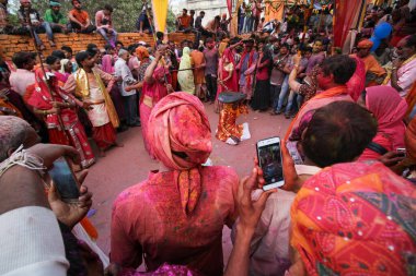 Mathura, Uttar Pradesh / Hindistan - 6 Ocak 2020: Hindistan 'daki Holi Festivali sırasında Mathura' da lathmaar holi oynayan insanların geniş açılı çekimi. Lathmaar Holi 'ye tanık olmak için tapınakta büyük bir kalabalık toplandı..