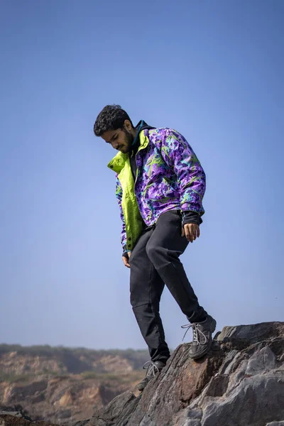 若いインドの少年の崖の上に雪のジャケットとトラックパンツを着て立っている 楽しさと自由の概念 — ストック写真