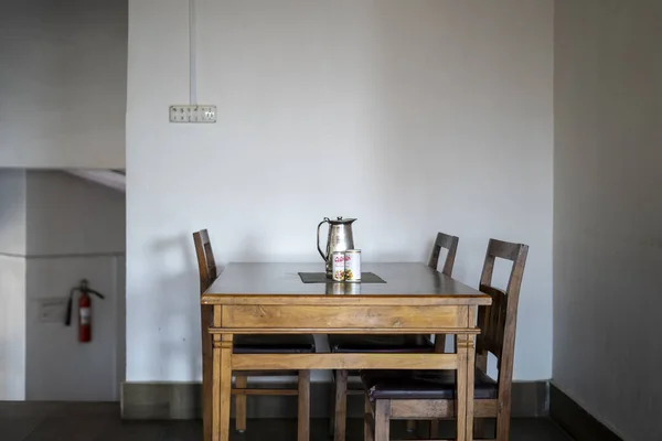 Lüks villadaki yemek alanının iç tasarımı, apartmanda ahşap yemek masası, bank ve beyaz yemek sandalyesi.